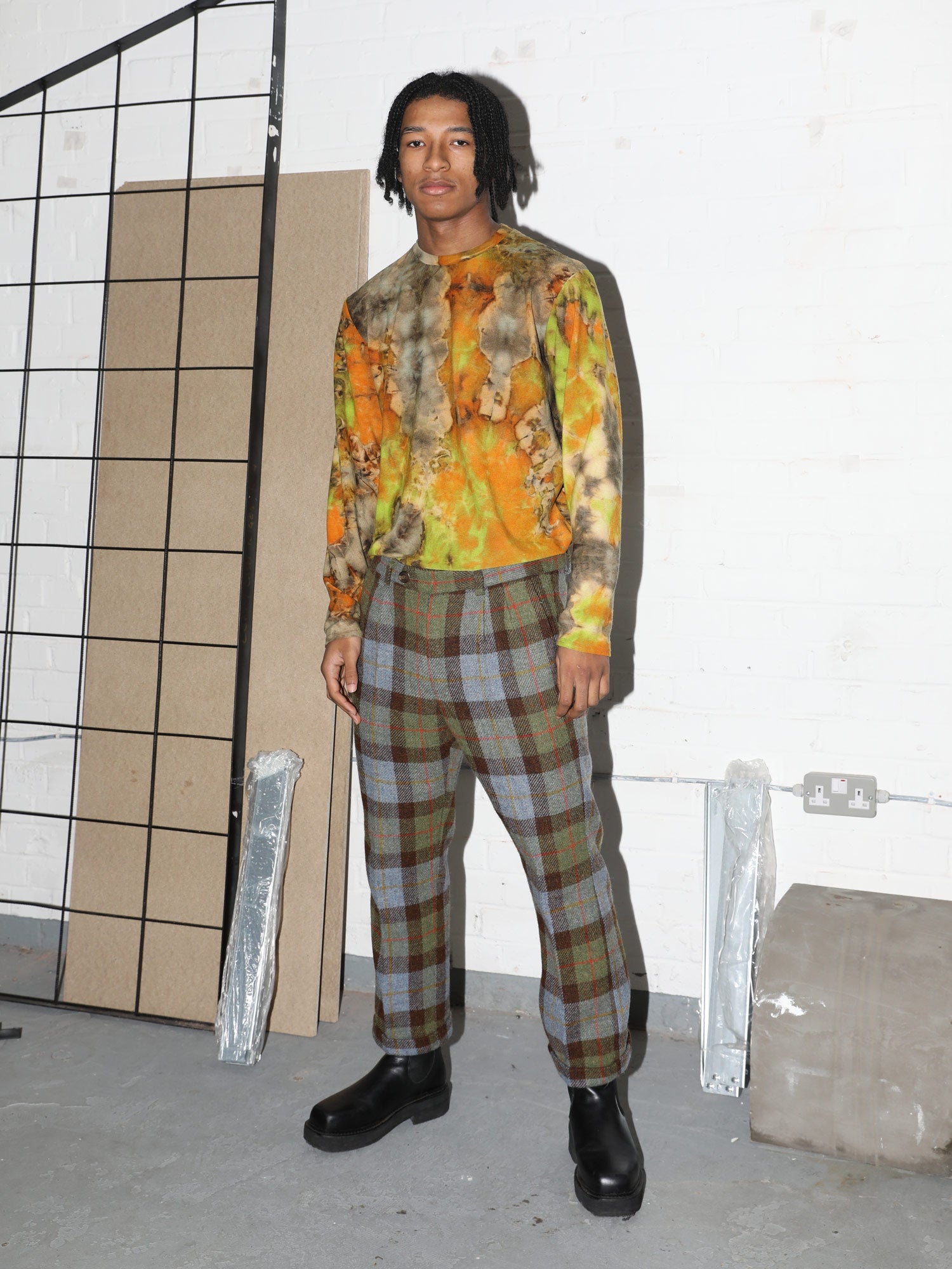 Model is styled in Rada Rada Canopy Acid, tie dye long sleeve t shirt. Styled with checkered woollen trousers. The pieces clash but work well.  