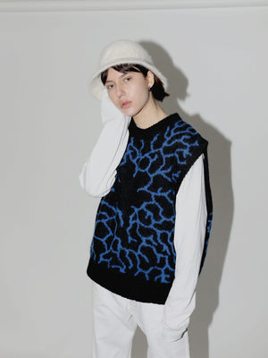 Model styled in all white with black and electric blue knitted mycelium vest on top. Many styling options.